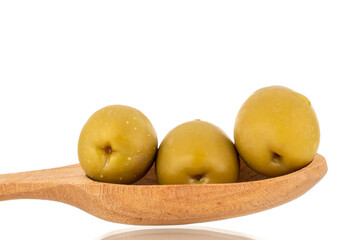 Several green pitted olives with a wooden spoon, macro, isolated on white.