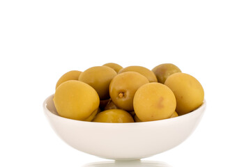 Several green pitted olives in a ceramic saucer, macro, isolated on white.
