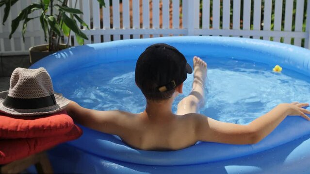 Happy kid having fun in swimming pool on the courtyard outdoor