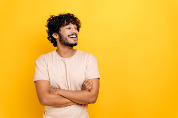 Charismatic attractive arabian or indian curly-haired guy in a t-shirt, freelancer, student,...