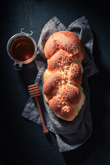 Healthy and homemade golden challah on dark table for breakfast.
