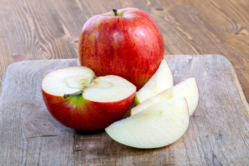 red ripe apple on a wooden chopping board