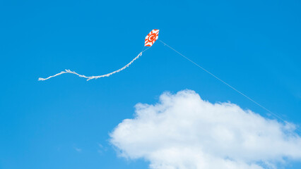 Turkish flag kite on the blue sky. 23 April Turkish flag kite. Kite flying in the blue cloudy bright sky.