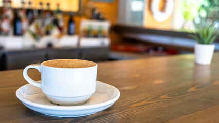 A coffee break while on vacation in the garden of the hotel. Coffee in a mug standing on the table in the garden. A coffee cup standing on the table in the natural area.