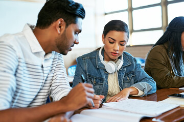 Doing it for our future. Cropped shot of two young university students working together in class.