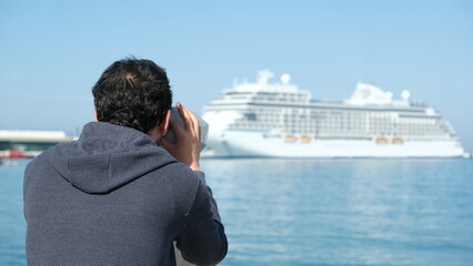 Man watch cruise ship on beach. Cruise ship. cruising desk. 