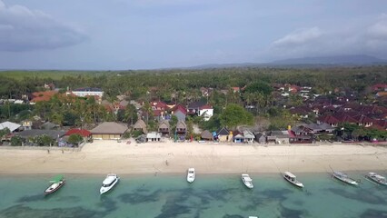 Daring high aerial view flight to Local huts on a withe sand beach. Feel tropical lifestyle of the best beach Bali´s at Mushroom Bay lembongan. Cinematic view from above by Philipp Marnitz summer 2017