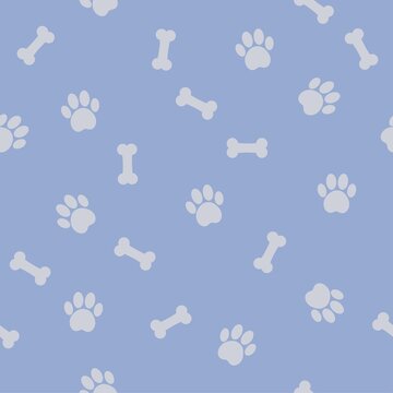 Cute and funny dog themed blue seamless pattern with paw print and bones