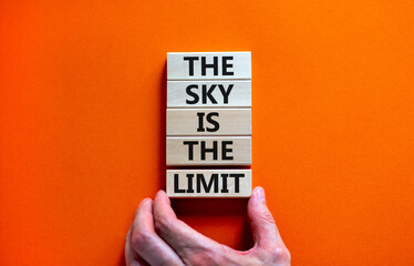 Sky is limit symbol. Concept words The sky is the limit on wooden blocks. Businessman hand. Beautiful orange table orange background. Business motivational stress spice of life concept. Copy space. - obrazy, fototapety, plakaty