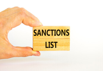 Sanctions list symbol. Wooden blocks with concept words Sanctions list on beautiful white background. Businessman hand. Business political sanctions list concept. Copy space.