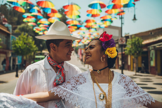 Dancers of typical Mexican dances from the region of Veracruz, Mexico, doing their performance in the street adorned with colored umbrellas.
