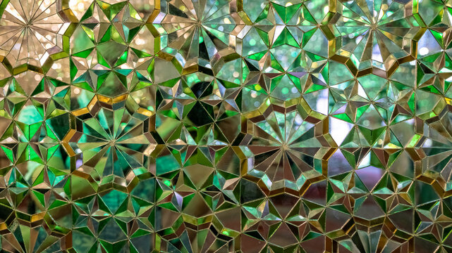Shiraz, Iran - May 2019: Interior design of Shah-e-Cheragh complex Shrine and mausoleum, the mirror mosque, decorated in green with numerous mirrors.