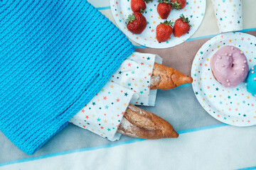 Picnic set with strawberries, baguette, knitted bag for picnic on plaid