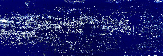 white grainy rust stain texture on blue metallic background with space for design. panoramic image of a blue metal wall with cracks, scratches and stained.