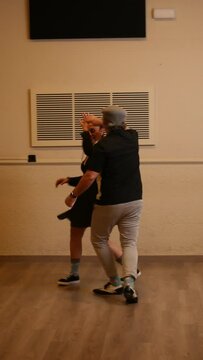 A senior adult couple dancing Lindy Hop in a studio