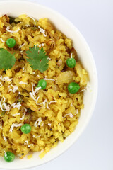 Kande Pohay OR Aloo Pohe is a popular Indian breakfast recipe made using Flattened rice, usually served with hot tea. Served in a bowl over moody background. Selective focus