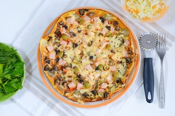 Healthy vegan lunch - homemade pizza with fresh vegetable salad and dill and parsley. Top view. Italian traditional meal on a light natural linen napkin. Cooking food at home. Menu, cafe, restaurant.