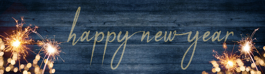 Golden bokeh lights flares and sparkler isolated on rustic blue colored wooden texture - Holiday...