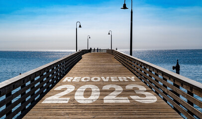 Recovery 2023 written on the wooden planks of a pier on the Pacific Coast	
