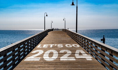 Let's Go 2024 written on the wooden planks of a pier on the Pacific Coast	
