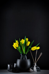 Bouquet of yellow tulips on a black background. Bright details, minimal composition, brightness of colors.