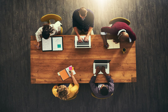 All set for a successful collaboration. High angle shot of a group of businesspeople having a meeting in a modern office.