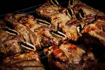 juicy beef rib and pork rib slowly being made on the grill on the fire at a gas barbecue