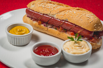 Lanche de linguiça calabresa inteira frita no pão baguete grande com gergelim e vinagrete...