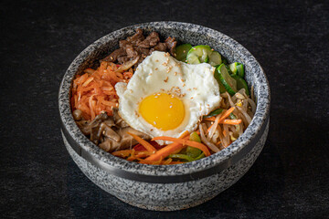 Dolsot Bibimbap with rice, vegetables and beef in a Stone Bowl