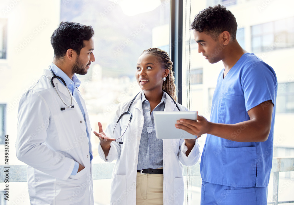 Poster shes got the perfect plan. shot of a group of doctors using a digital tablet at work.