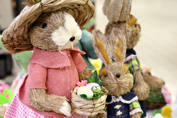 Easter Bunny with eggs in wicker basket. Straw toys and festive decorations
