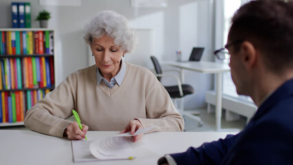 Naklejka na ściany i meble Senior woman sign papers for educational program 