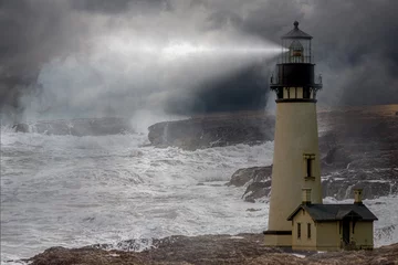 Foto auf Acrylglas a tall whit lighthouse shinning light at night in a storm with a rough ocean and fog © Ralph Lear