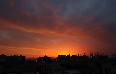 Haifa port on early morning. City silhouette on dramatic sky background.  