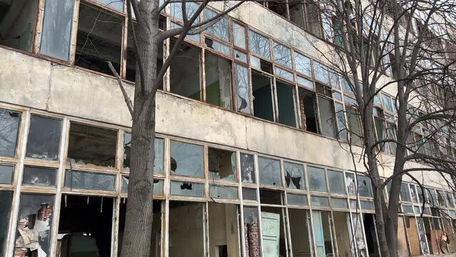 Abandoned concrete industrial building with broken windows. Old factory for demolition