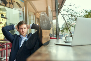 Feeling relaxed after a hard days work. Portrait of a young businessman looking relaxed while sitting in a coffee shop.