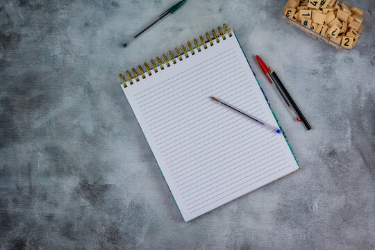 Lined notebook with pen on right side and gray background