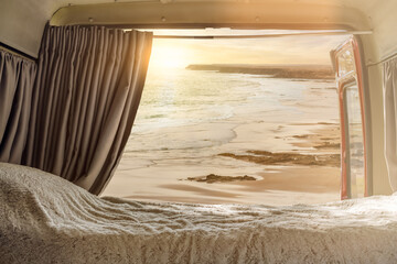 View from the inside of a campervan adapted for the sunset on the beach - freedom concept - digital...