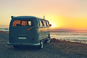 Fototapeta na wymiar Adventures on the horizon. Shot of a minivan parked at the beach at sunset.