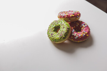 Pink and green donuts with powder. Delicacy.