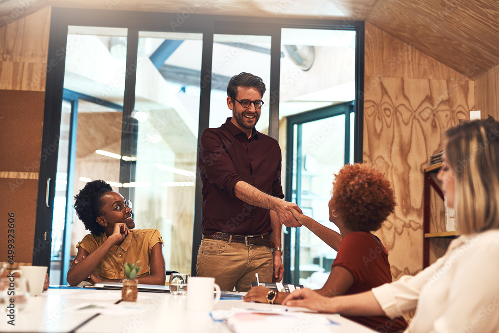 Poster making introductions around the boardroom. shot of businesspeople shaking hands during a meeting in 