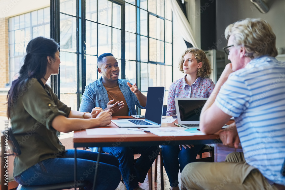 Poster tackling a project like the pros that they are. shot of a diverse group of businesspeople having a m