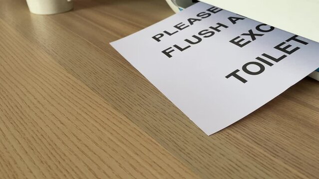 Printing &ldquo;PLEASE DO NOT FLUSH ANYTHING EXCEPT TOILET PAPAER&rdquo; text written message word on paper sheet A4 document being printed from multifunction scanner printer