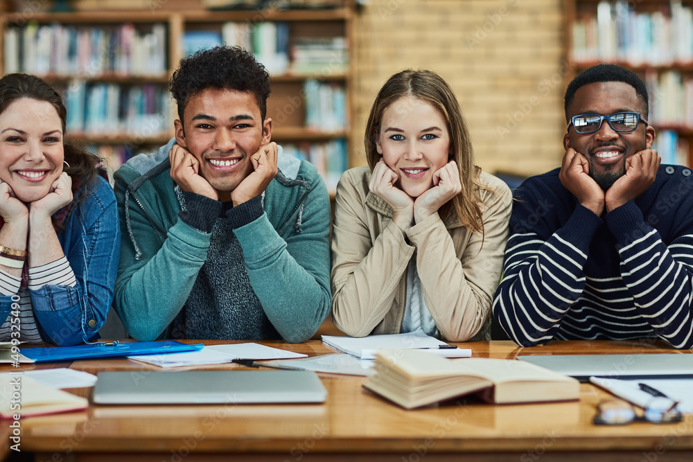 Poster Education is the gateway to greater things. Portrait of a group of university students sitting in the library at campus.