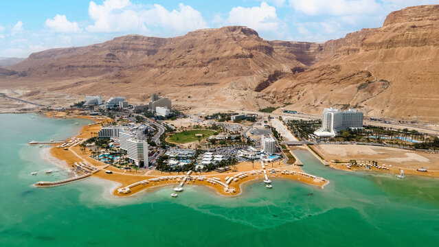 Dead sea beach shore tourist hotels, salt water, daylight Ein Bokek Panorama aerial view