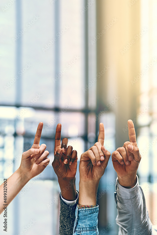 Poster on the up. cropped shot of a group of unrecognizable businesspeople pointing upwards.