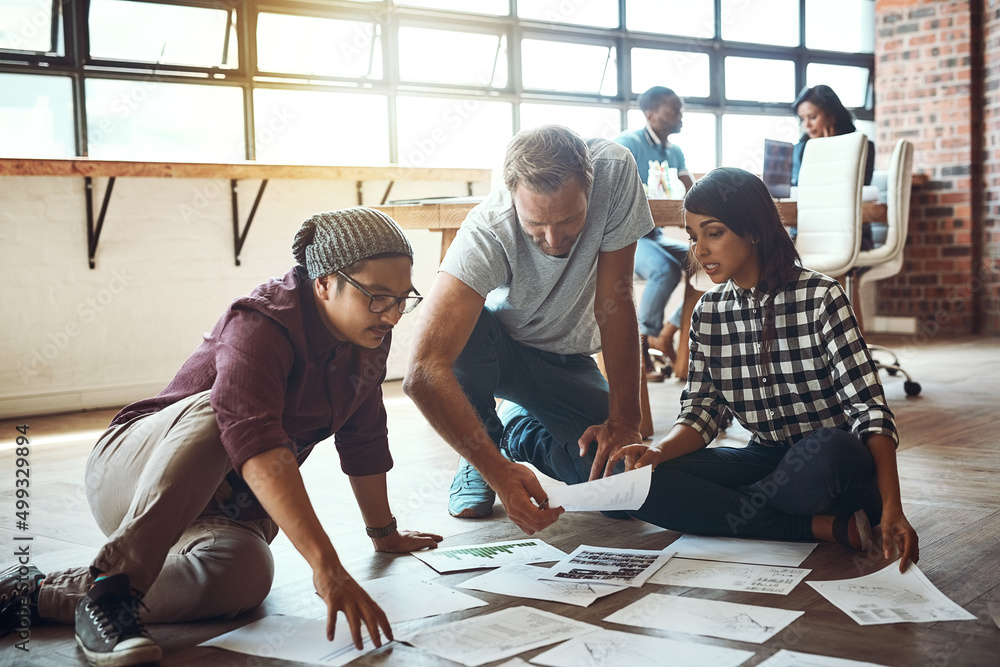 Canvas Prints Together we can create ideas for success. Shot of a team of entrepreneurs collaborating and sitting on the floor in a modern office.