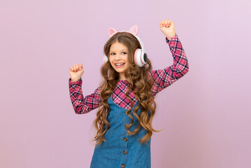 A child wearing headphones on an isolated purple background. a little girl listens to music.