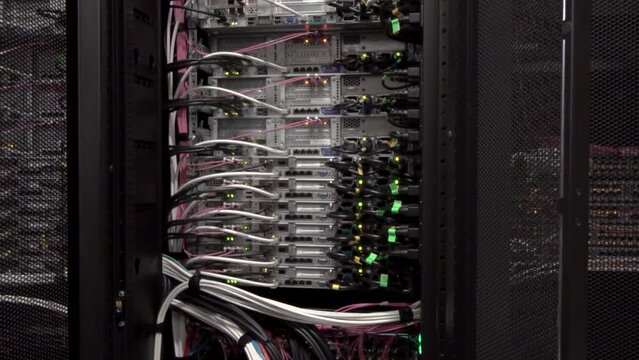 back side of working data servers with flashing LED lights. Working Data Center Full of Server RacksThe server room has a lot of wires.the camera moves away hd