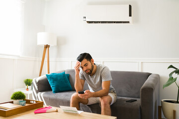 Sad man feeling hot without the air conditioner